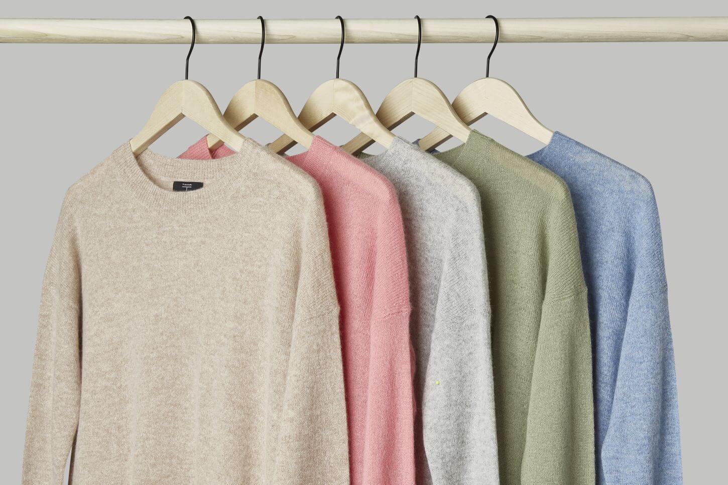 Cashmere sweaters on hangers on a rack